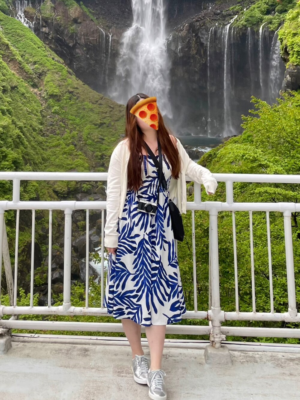 ブラック系のショルダーバッグ、ブルー系のワンピース、シルバー系のスニーカーを着用したレディースの春コーディネートの1枚目の写真