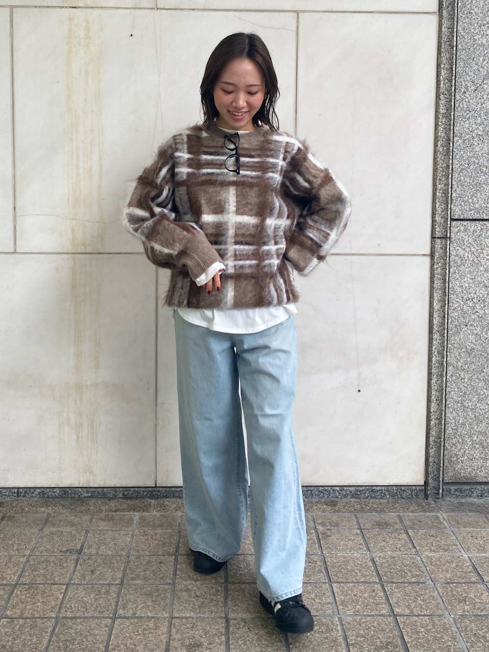 ホワイト系のTシャツ/カットソー、ブルー系のデニムパンツ、ブラウン系のニット/セーターを着用したレディースの秋コーディネートの1枚目の写真