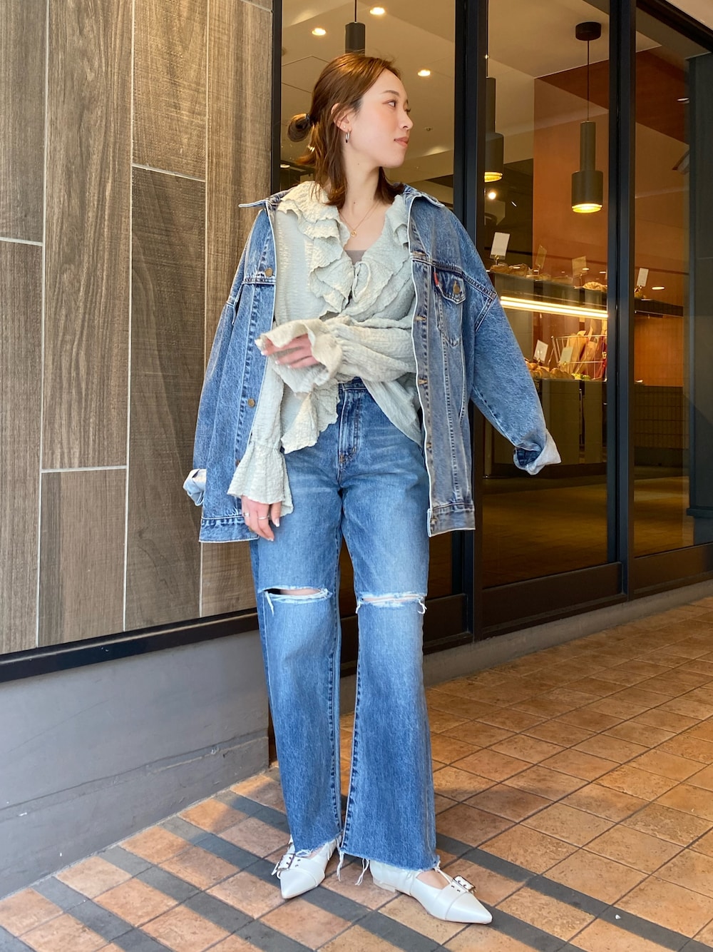 ブルー系のデニムジャケット、グリーン系のシャツ/ブラウス、ブルー系のデニムパンツを着用したレディースの春コーディネートの1枚目の写真