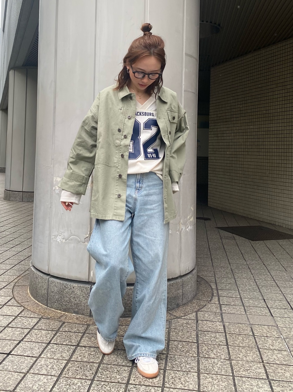 ブルー系のデニムパンツ、グリーン系のミリタリージャケット、ホワイト系のTシャツ/カットソーを着用したレディースの春コーディネートの1枚目の写真