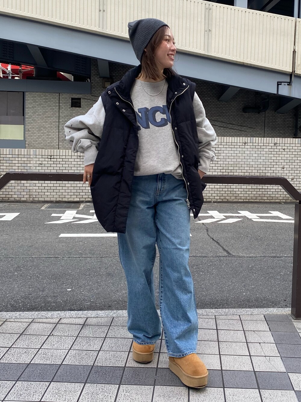 ブルー系のデニムパンツ、グレー系のスウェット、ブラック系のダウンジャケット/コートを着用したレディースの冬コーディネートの1枚目の写真