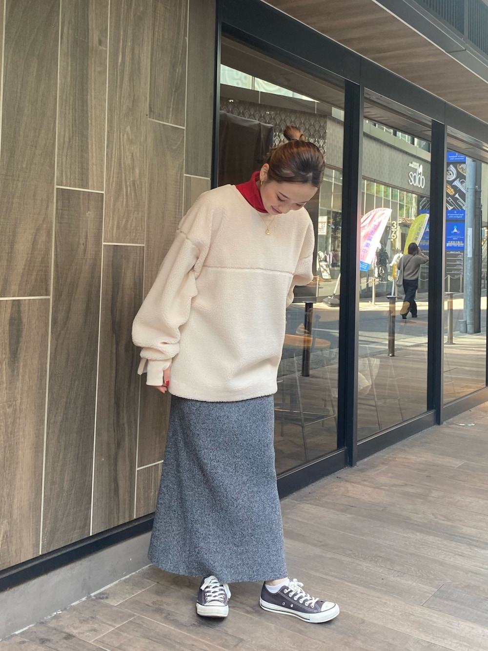 ホワイト系のTシャツ/カットソー、グレー系のスカート、レッド系のニット/セーターを着用したレディースの秋コーディネートの1枚目の写真