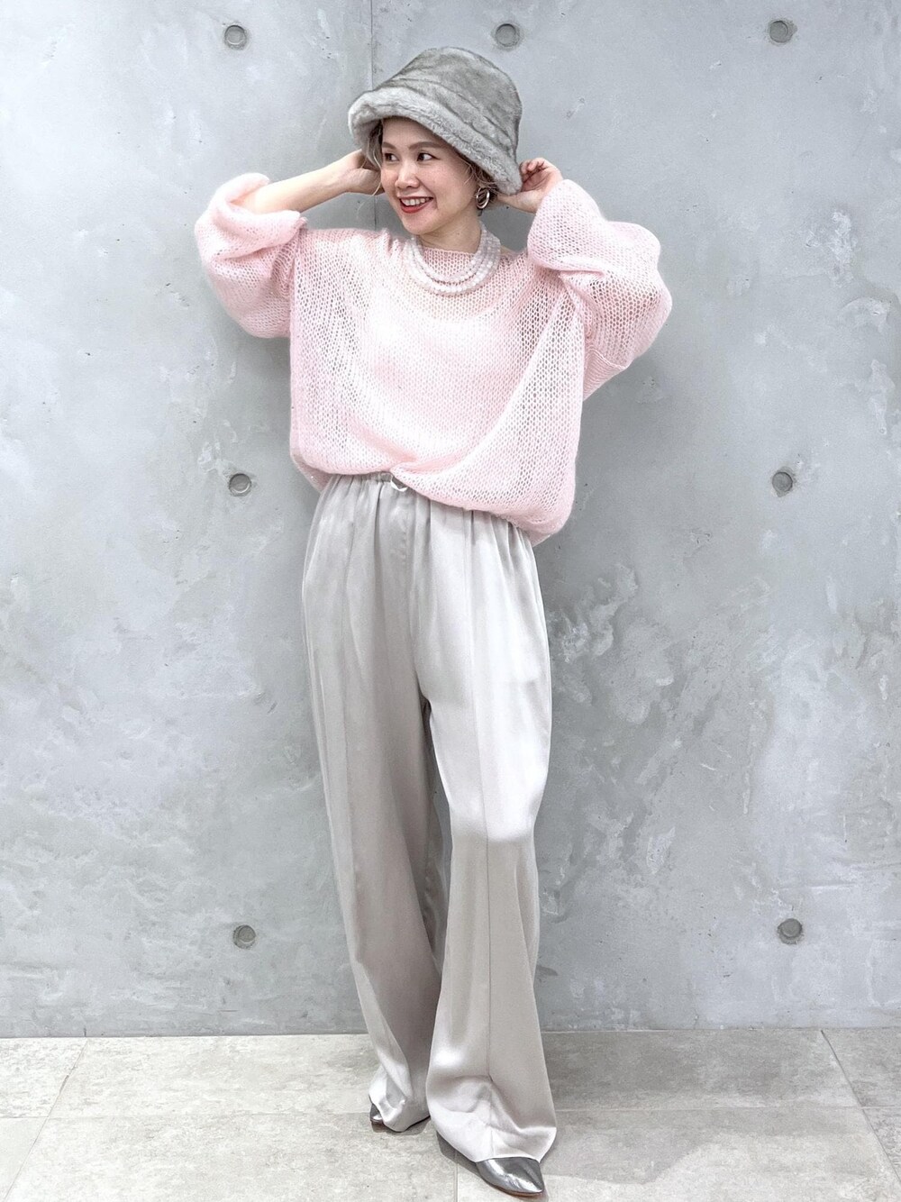 グレー系のその他パンツ、ピンク系のニット/セーター、シルバー系のパンプスを着用したレディースの夏コーディネートの1枚目の写真