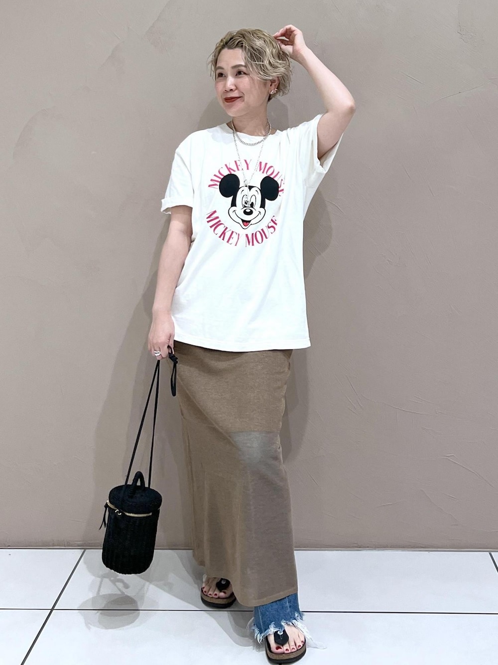 ブラック系のショルダーバッグ、ホワイト系のTシャツ/カットソー、ブルー系のデニムパンツを着用したレディースの夏コーディネートの1枚目の写真