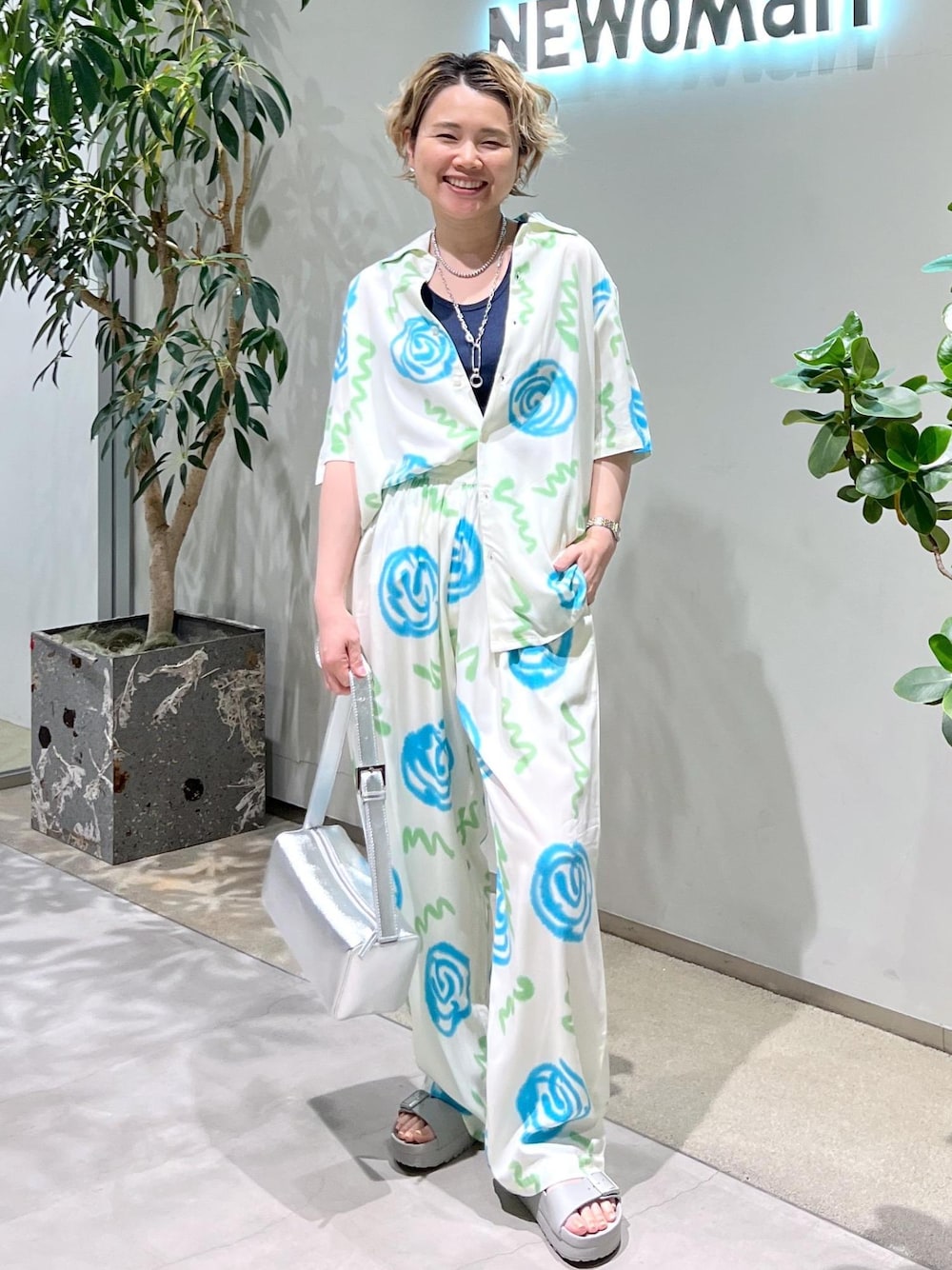 ブルー系のタンクトップ、シルバー系のショルダーバッグ、グレー系のサンダルを着用したレディースの春コーディネートの1枚目の写真