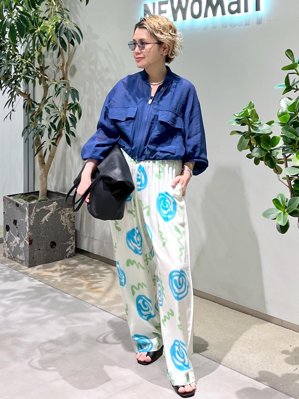 ブラック系のサンダル、ブルー系のブルゾン、ブラック系のサングラスを着用したレディースの春コーディネートの1枚目の写真