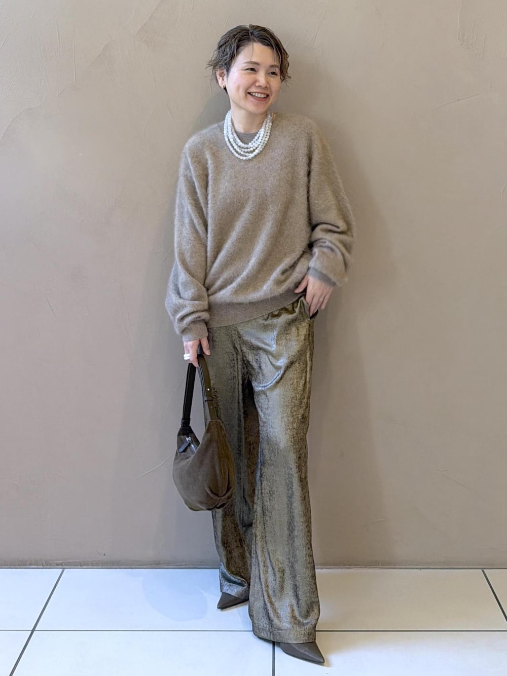 ゴールド系のその他パンツ、ベージュ系のニット/セーター、グリーン系のパンプスを着用したレディースの冬コーディネートの1枚目の写真