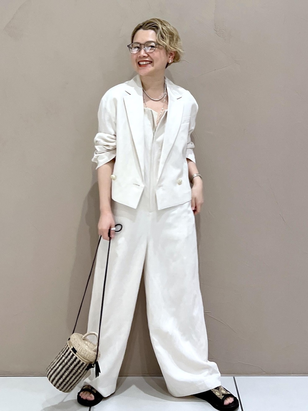 ホワイト系のテーラードジャケット、ホワイト系のつなぎ/オールインワン、ホワイト系のショルダーバッグを着用したレディースの春コーディネートの1枚目の写真