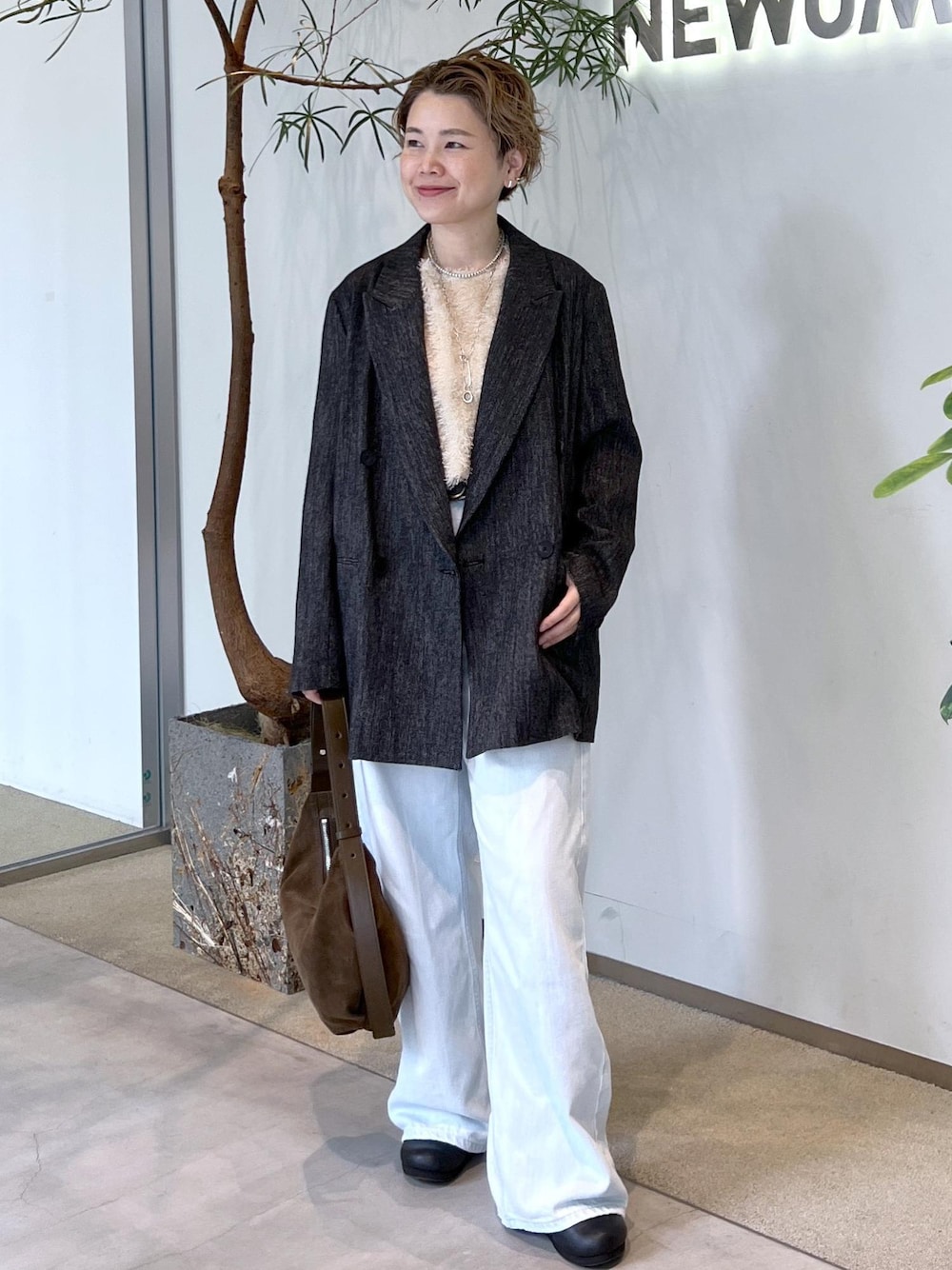 ブルー系のデニムパンツ、ベージュ系のその他トップス、ブラック系のテーラードジャケットを着用したレディースの秋コーディネートの1枚目の写真