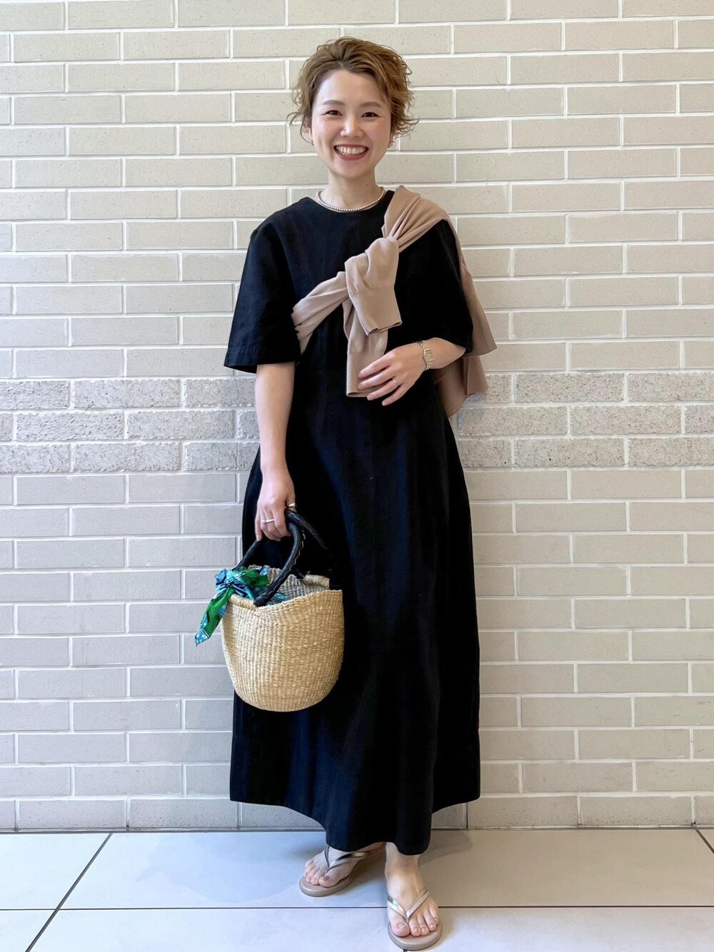 ベージュ系のサンダル、ベージュ系のカーディガン/ボレロ、ブラック系のワンピースを着用したレディースの夏コーディネートの1枚目の写真