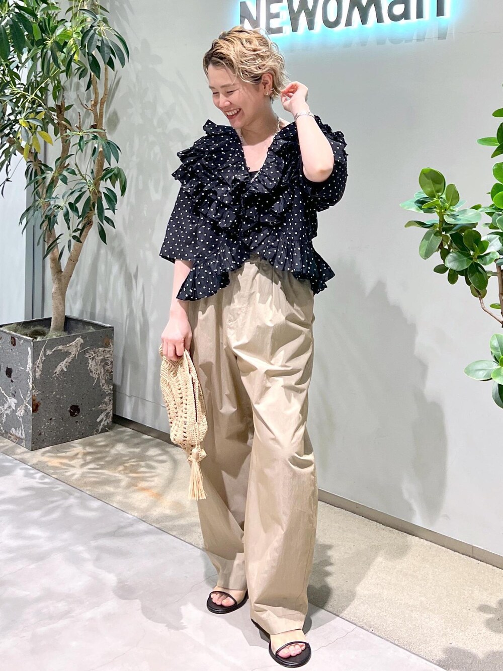 ベージュ系のその他パンツ、ブラック系のシャツ/ブラウス、ホワイト系のサンダルを着用したレディースの春コーディネートの1枚目の写真