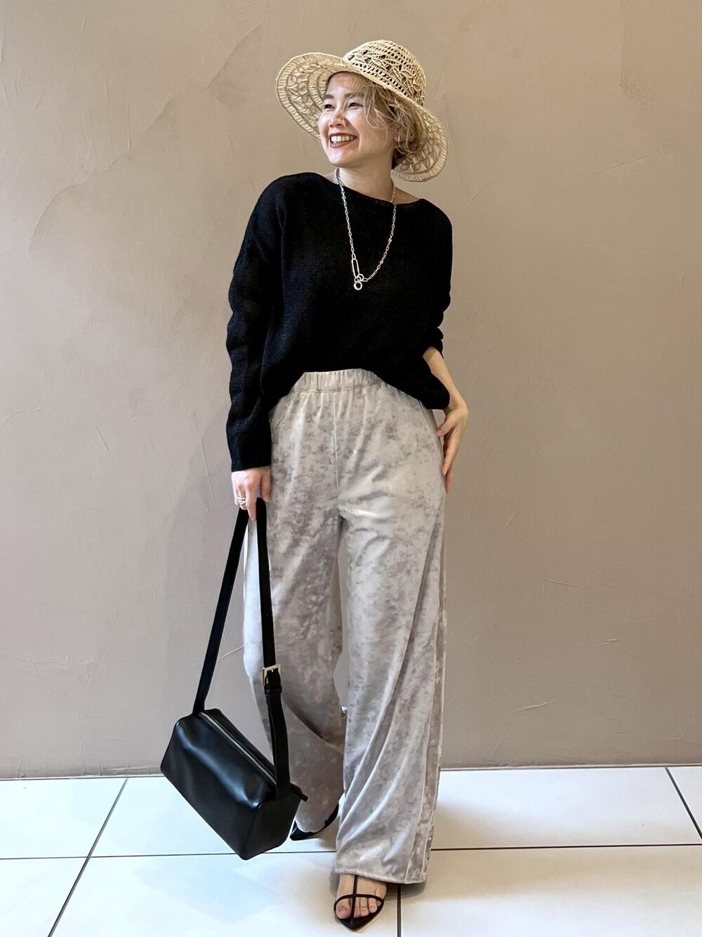 ベージュ系のその他パンツ、ブラック系のサンダル、ブラック系のニット/セーターを着用したレディースの春コーディネートの1枚目の写真