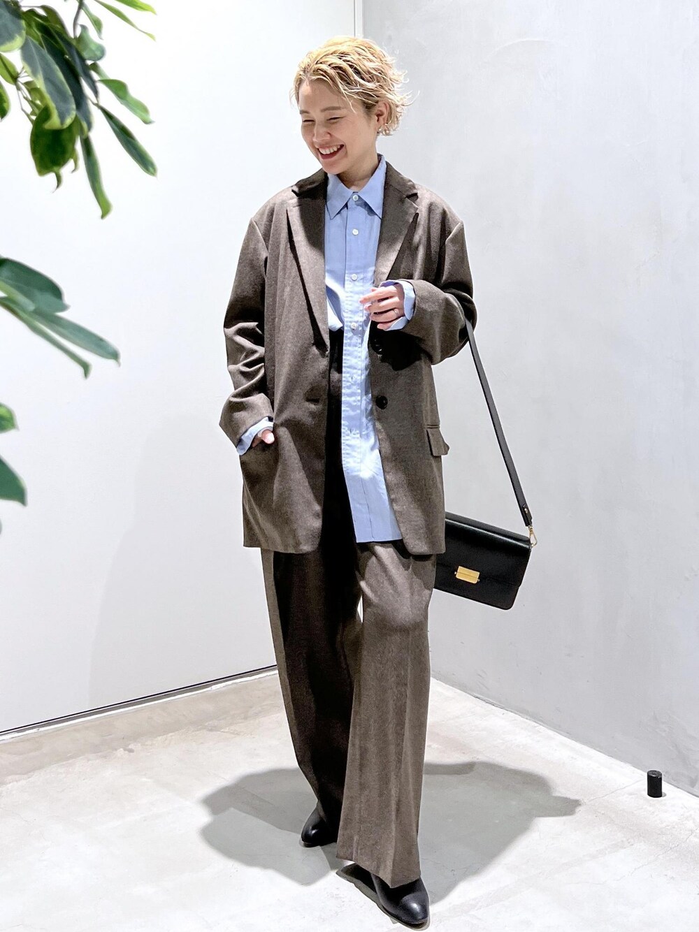 ブルー系のシャツ/ブラウス、ブラック系のショルダーバッグ、ブラウン系のスラックスを着用したレディースの秋コーディネートの1枚目の写真