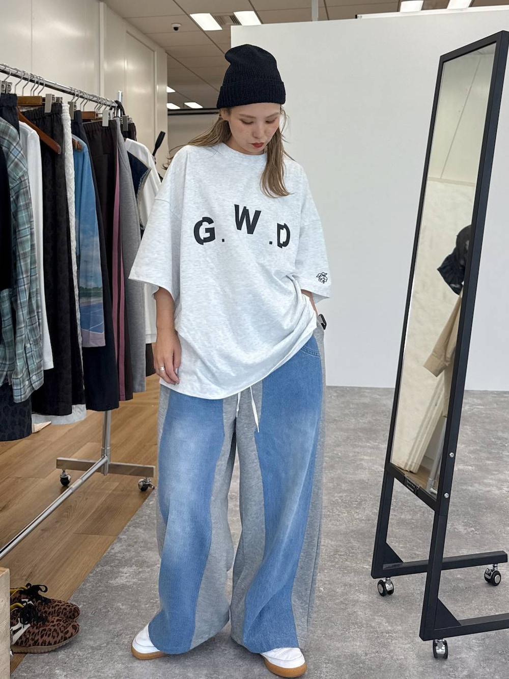 グレー系のデニムパンツ、ブラック系のニットキャップ/ビーニーを着用したレディースの夏コーディネートの1枚目の写真