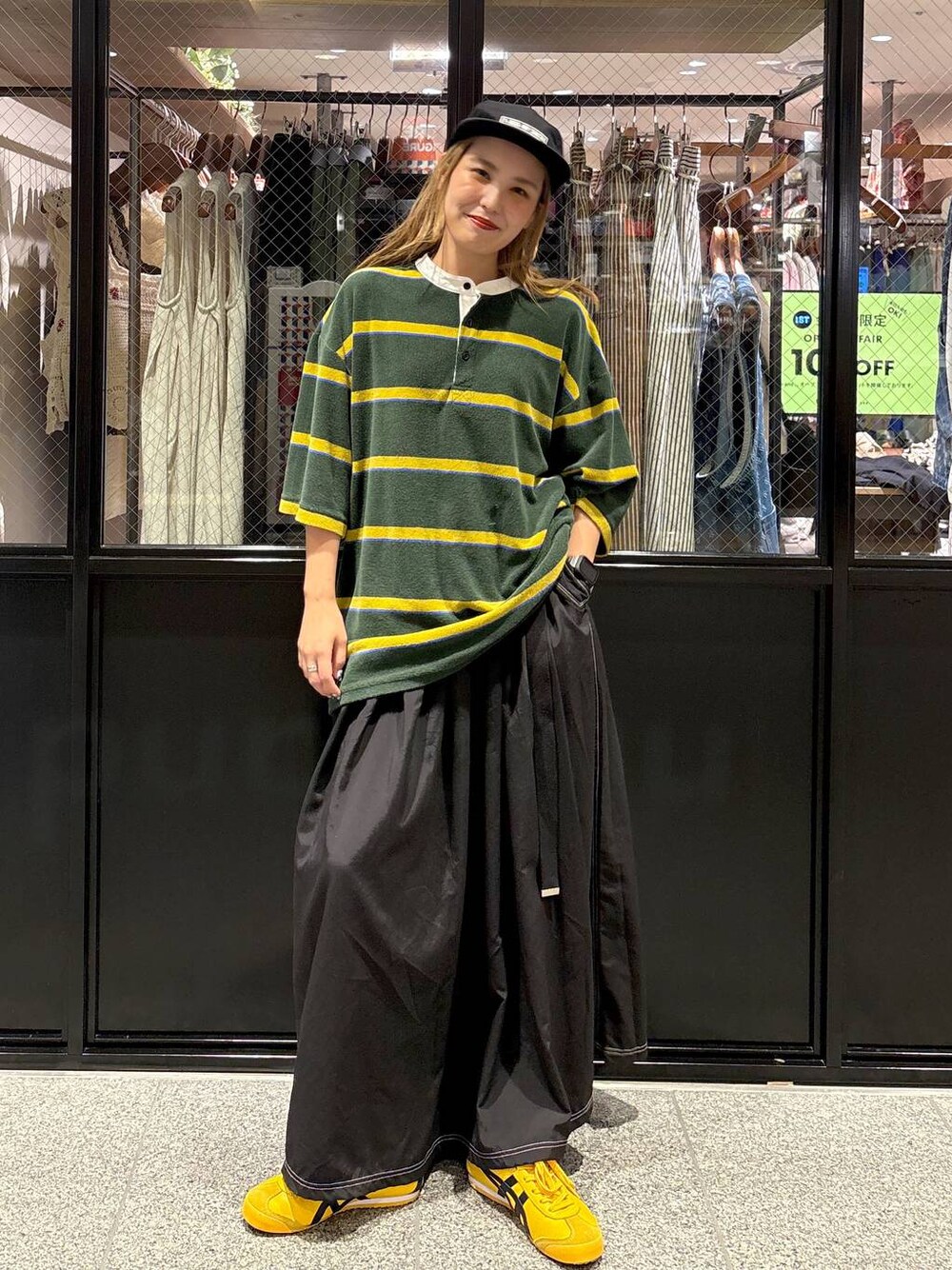 グリーン系のTシャツ/カットソー、ブラック系のキャップを着用したレディースの夏コーディネートの1枚目の写真