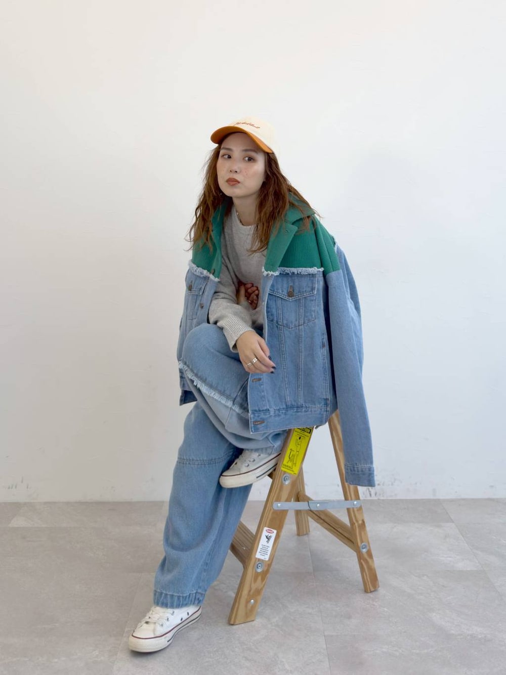 ブルー系のデニムパンツ、グレー系のニット/セーターを着用したレディースの冬コーディネートの1枚目の写真