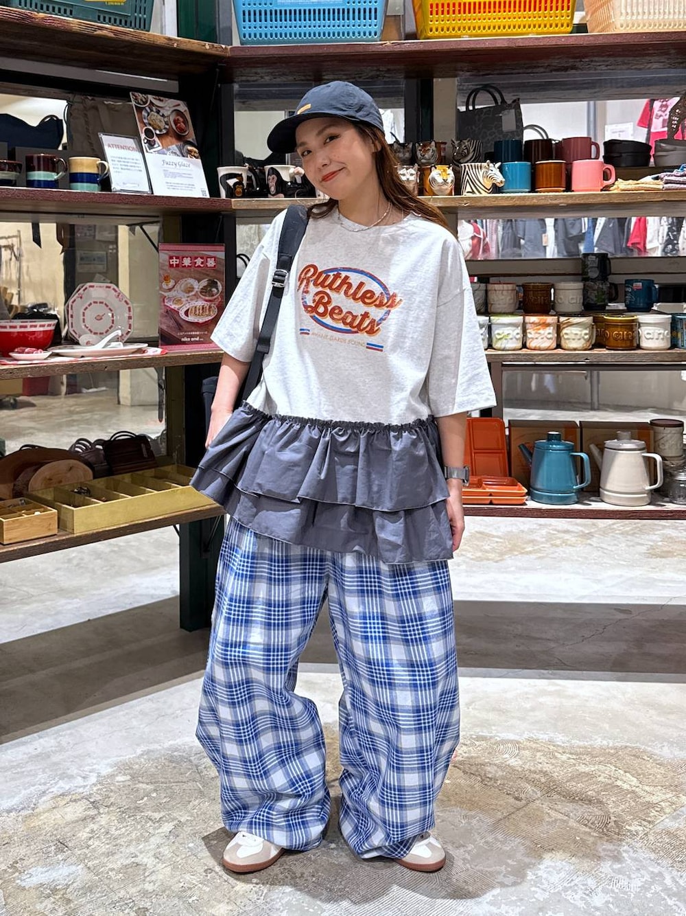 ベージュ系のスニーカー、ブラック系のバックパック/リュック、グレー系のTシャツ/カットソーを着用したレディースの春コーディネートの1枚目の写真