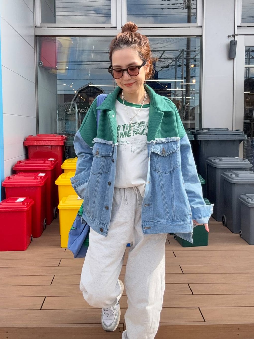 グレー系のスウェットパンツ、ブルー系のデニムジャケットを着用したレディースの冬コーディネートの1枚目の写真