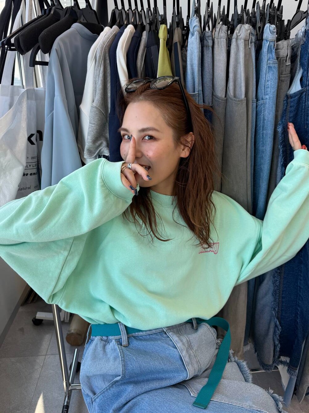 ブルー系のデニムスカート、グリーン系のTシャツ/カットソーを着用したレディースの冬コーディネートの1枚目の写真