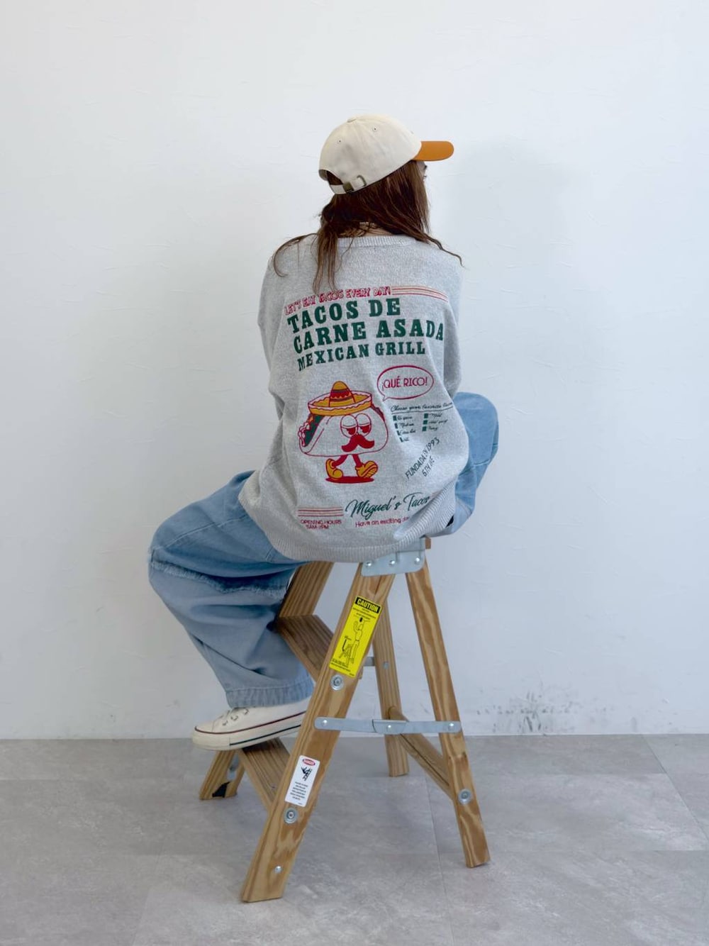 ブルー系のデニムパンツ、グレー系のニット/セーターを着用したレディースの冬コーディネートの1枚目の写真