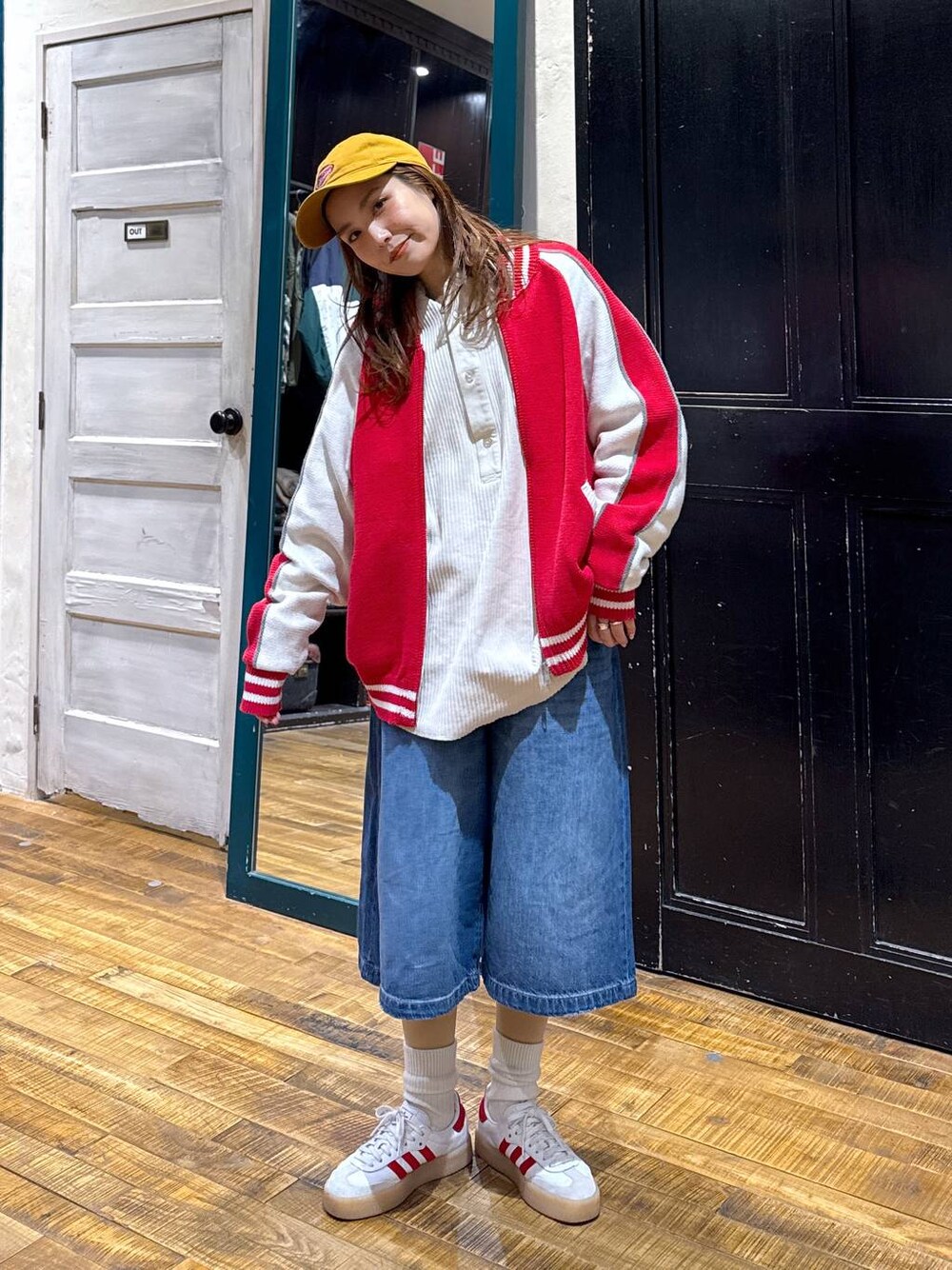 ブルー系のデニムパンツ、ホワイト系のTシャツ/カットソー、レッド系のカーディガン/ボレロを着用したレディースの冬コーディネートの1枚目の写真