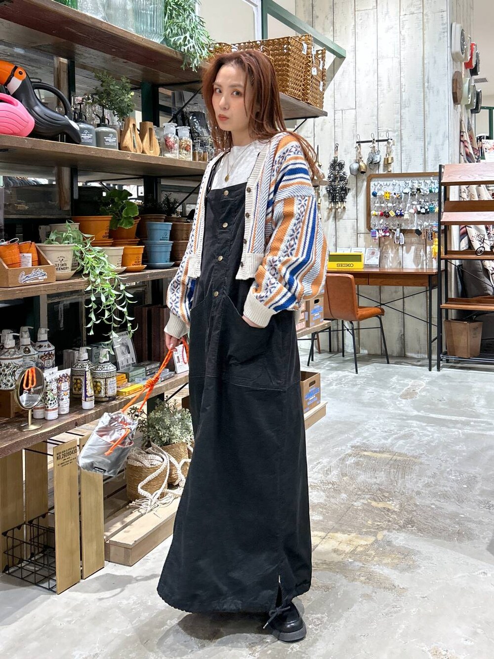 ブラック系のローファー、オレンジ系のカーディガン/ボレロ、グレー系のショルダーバッグを着用したレディースの冬コーディネートの1枚目の写真