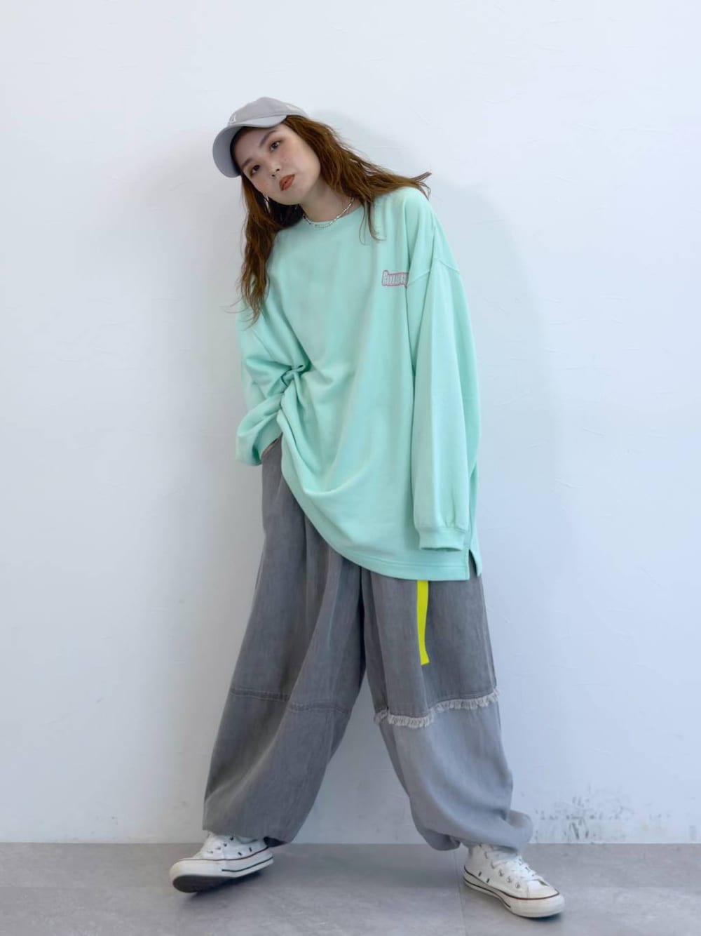 グレー系のデニムパンツ、グリーン系のTシャツ/カットソーを着用したレディースの冬コーディネートの1枚目の写真
