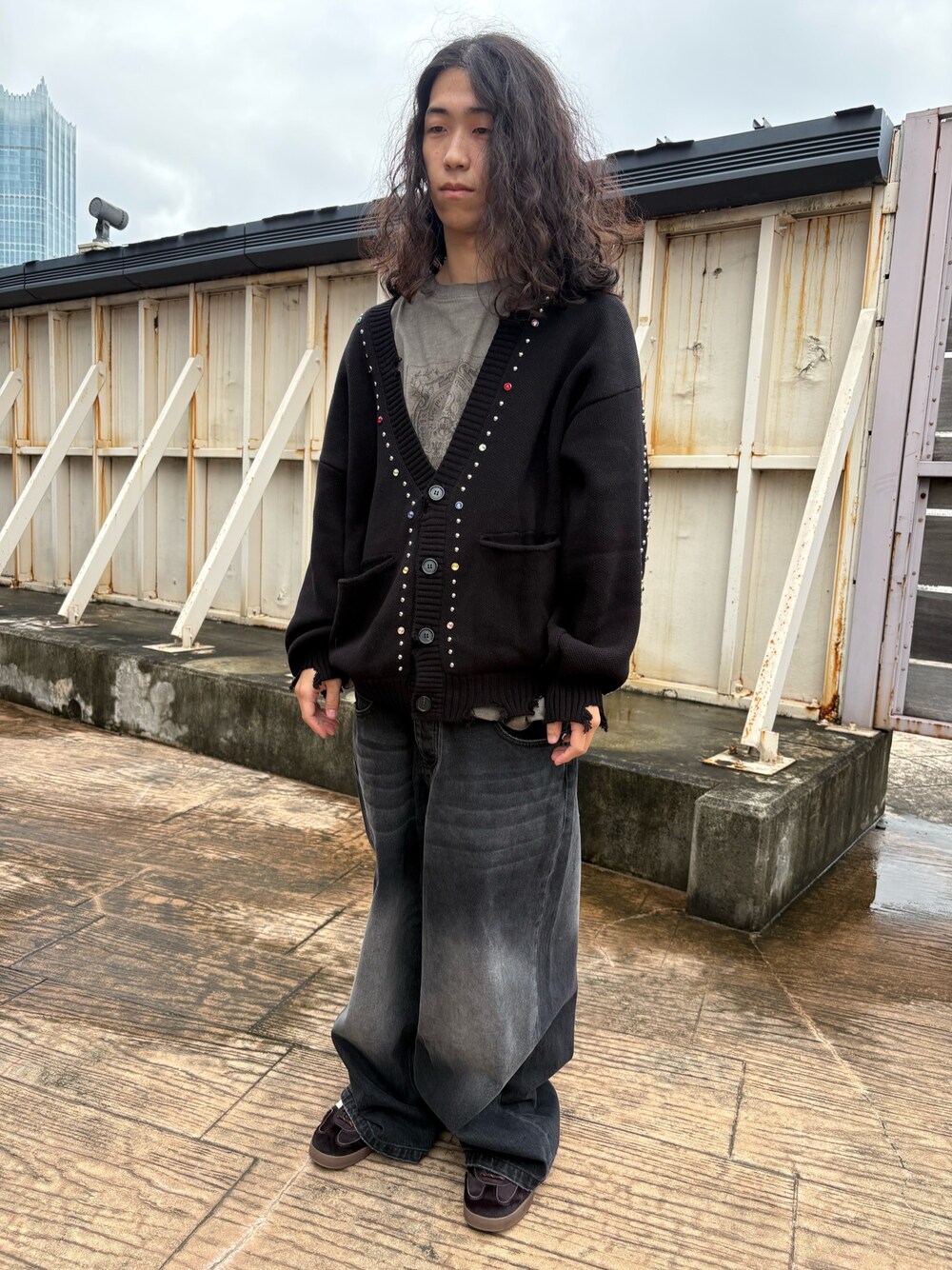 ブラック系のカーディガン/ボレロ、ベージュ系のTシャツ/カットソー、ブラック系のデニムパンツを着用したメンズの秋コーディネートの1枚目の写真
