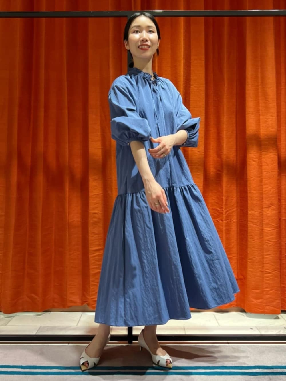 ホワイト系のパンプス、ブルー系のワンピースを着用したレディースの春コーディネートの1枚目の写真
