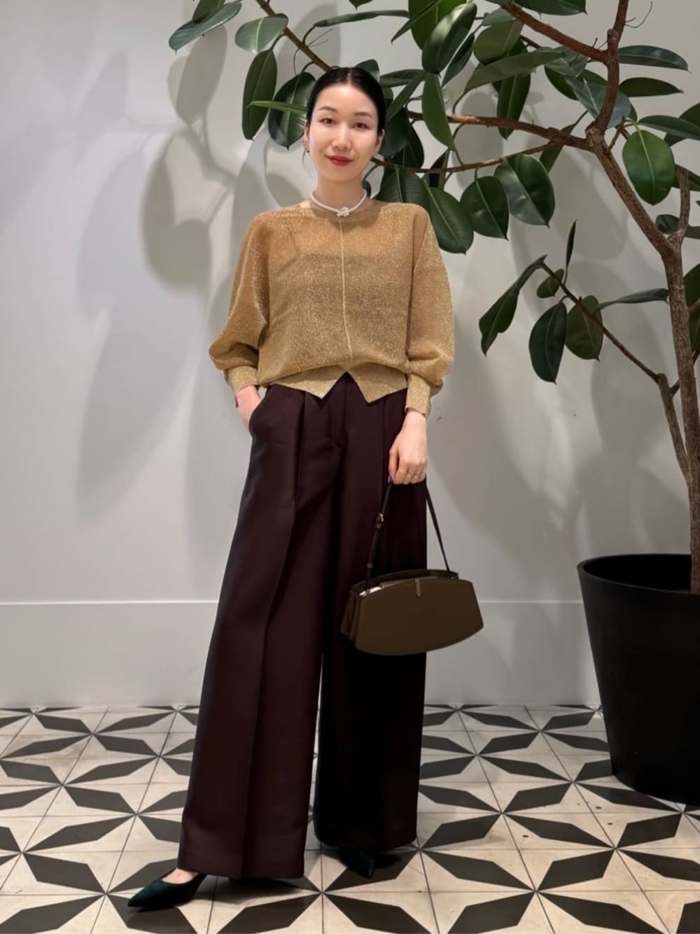 イエロー系のスラックス、グレー系のキャミソール、ゴールド系のニット/セーターを着用したレディースの夏コーディネートの1枚目の写真