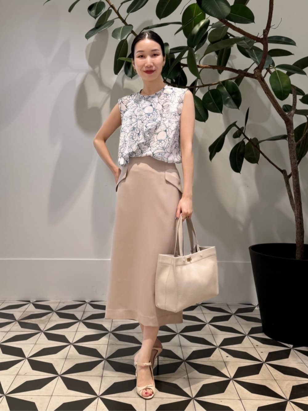 ホワイト系のキャミソール、ホワイト系のシャツ/ブラウス、ベージュ系のスカートを着用したレディースの夏コーディネートの1枚目の写真