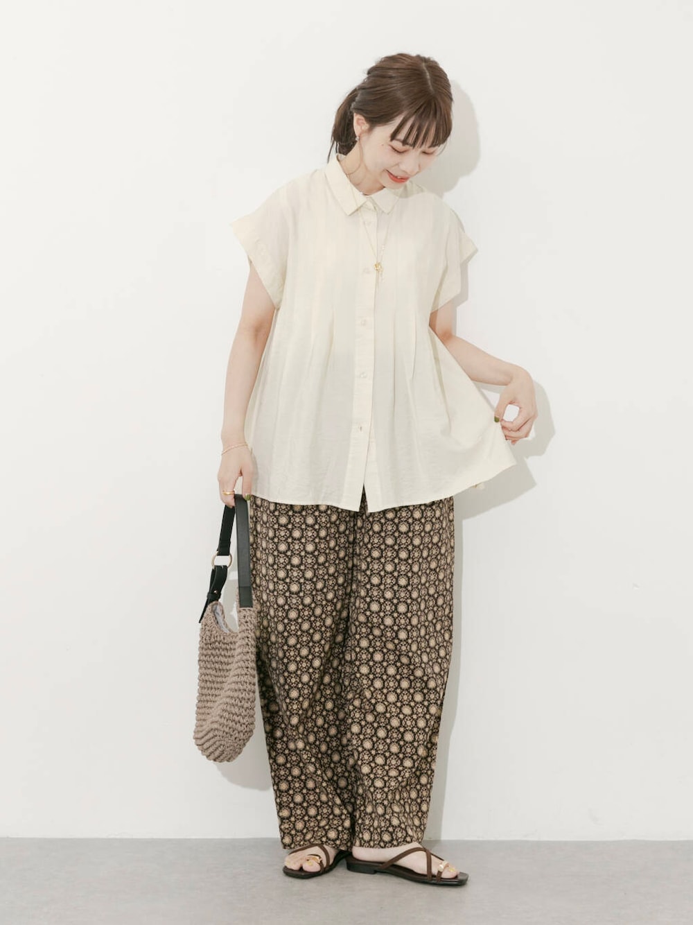 グレー系のトートバッグ、ホワイト系のシャツ/ブラウス、ブラック系のその他パンツを着用したレディースの夏コーディネートの1枚目の写真