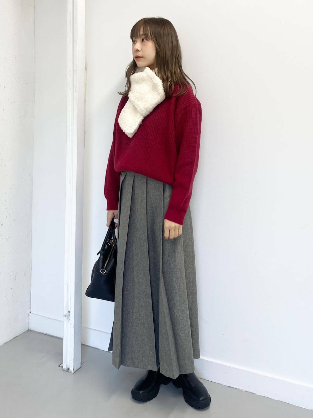 ブラック系のブーツ、ブラック系のボストンバッグ、グレー系のスカートを着用したレディースの冬コーディネートの1枚目の写真