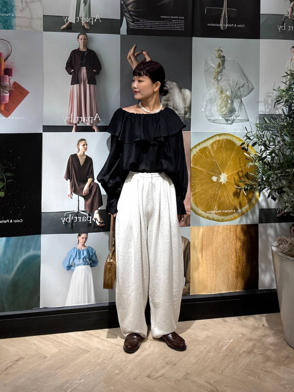 ブラック系のシャツ/ブラウス、グレー系のスウェットパンツ、イエロー系のショルダーバッグを着用したレディースの夏コーディネートの1枚目の写真