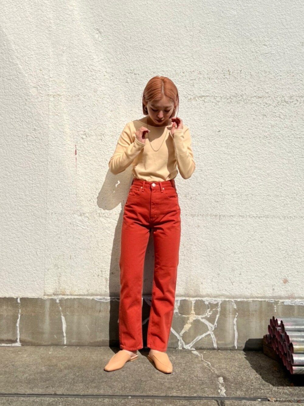 レッド系のデニムパンツ、ベージュ系のTシャツ/カットソー、ベージュ系のその他シューズを着用したレディースの冬コーディネートの1枚目の写真