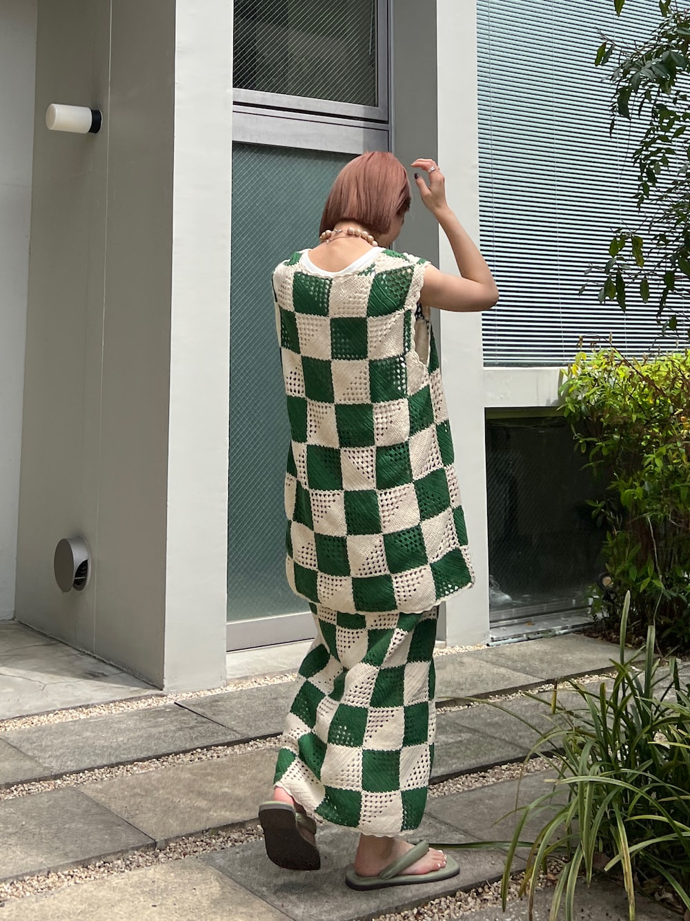 グリーン系のニット/セーター、グリーン系のスカート、グリーン系のサンダルを着用したレディースの春コーディネートの1枚目の写真