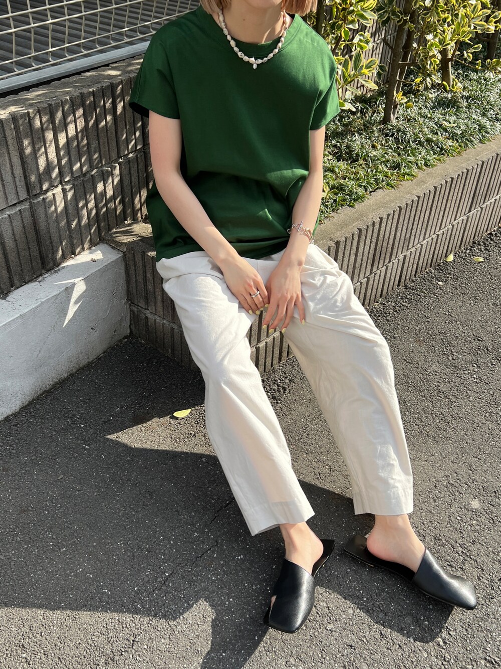 グリーン系のTシャツ/カットソー、ブラック系のサンダル、ホワイト系のその他パンツを着用したレディースの春コーディネートの1枚目の写真