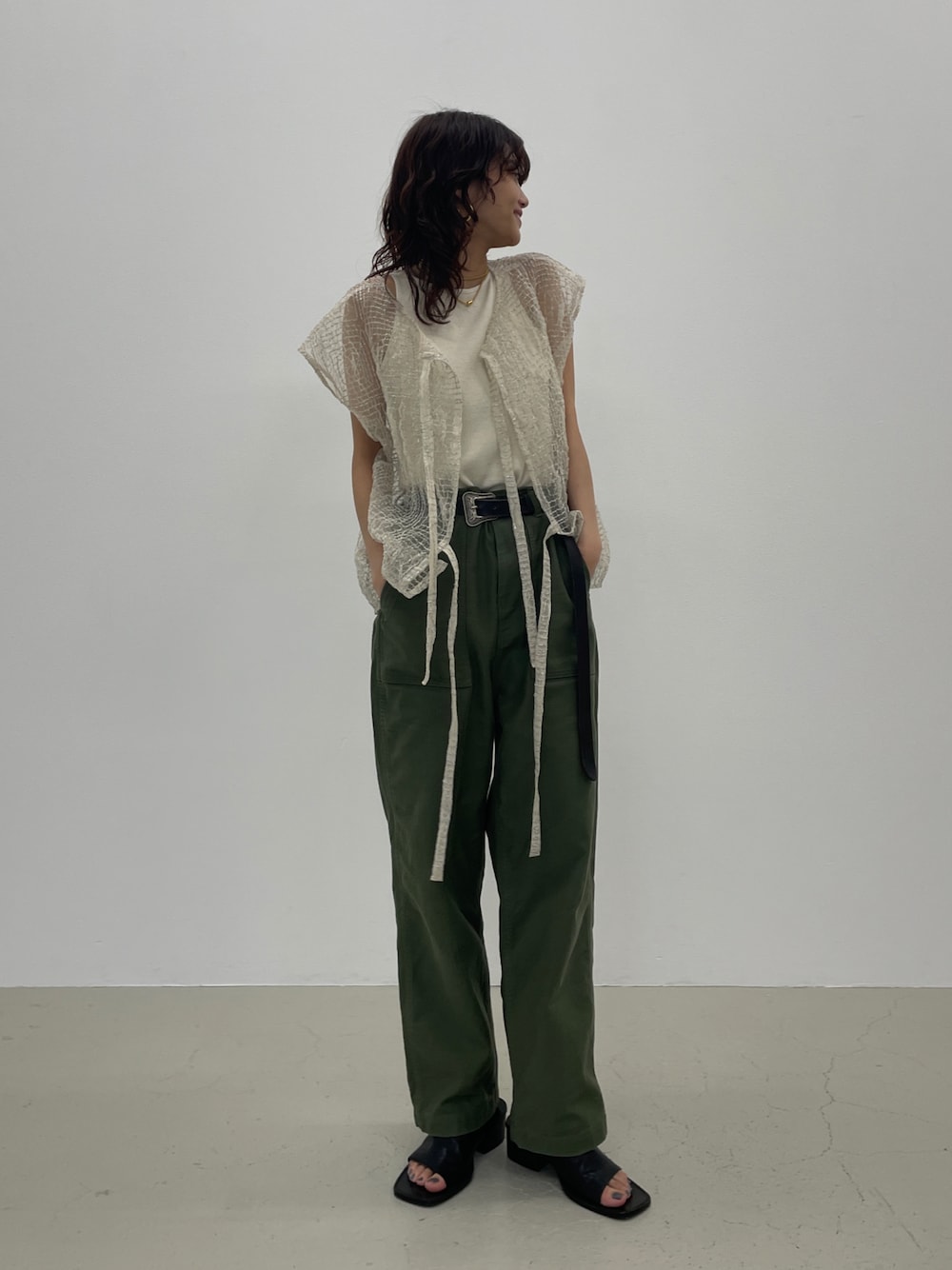 シルバー系のカーディガン/ボレロ、グリーン系のカーゴパンツ、ブラック系のサンダルを着用したレディースの春コーディネートの1枚目の写真