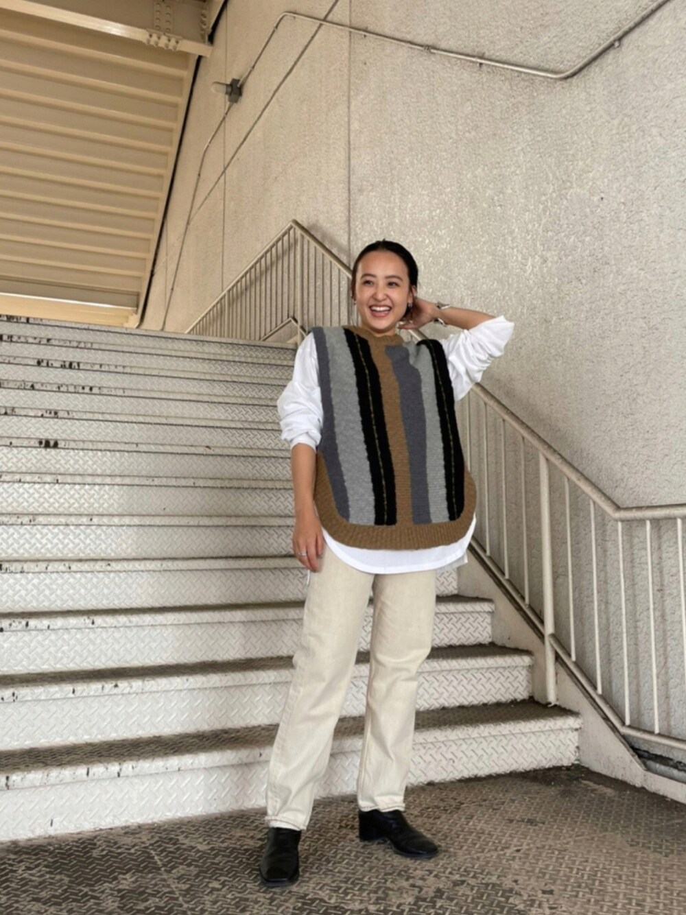 ベージュ系のデニムパンツ、ブルー系のニット/セーター、ホワイト系のTシャツ/カットソーを着用したレディースの秋コーディネートの1枚目の写真