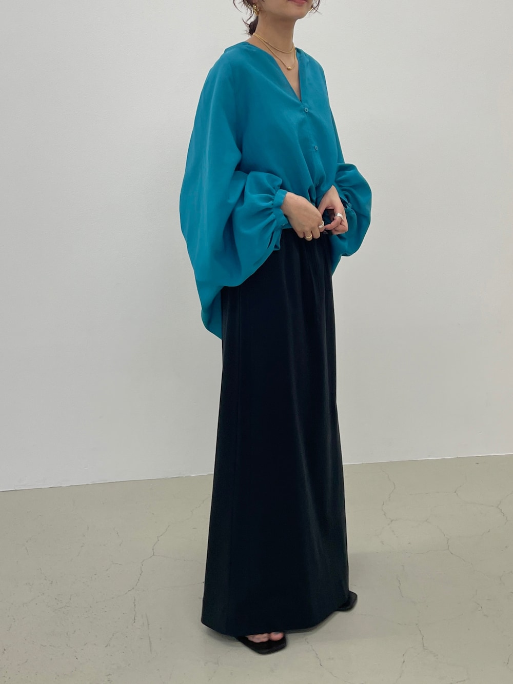 ブルー系のシャツ/ブラウス、ブラック系のスカートを着用したレディースの春コーディネートの1枚目の写真