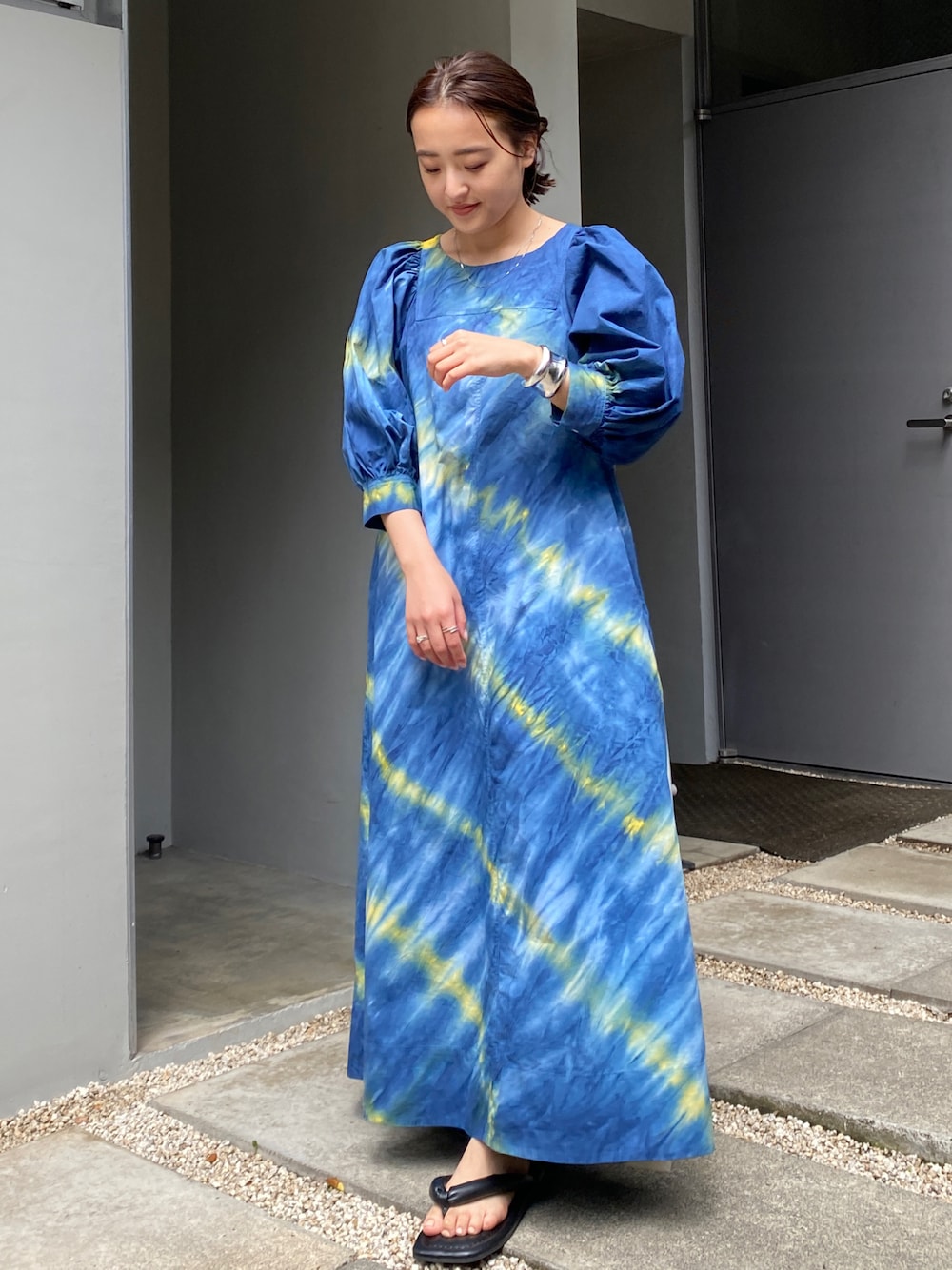 ブルー系のワンピース、ブラック系のサンダルを着用したレディースの夏コーディネートの1枚目の写真