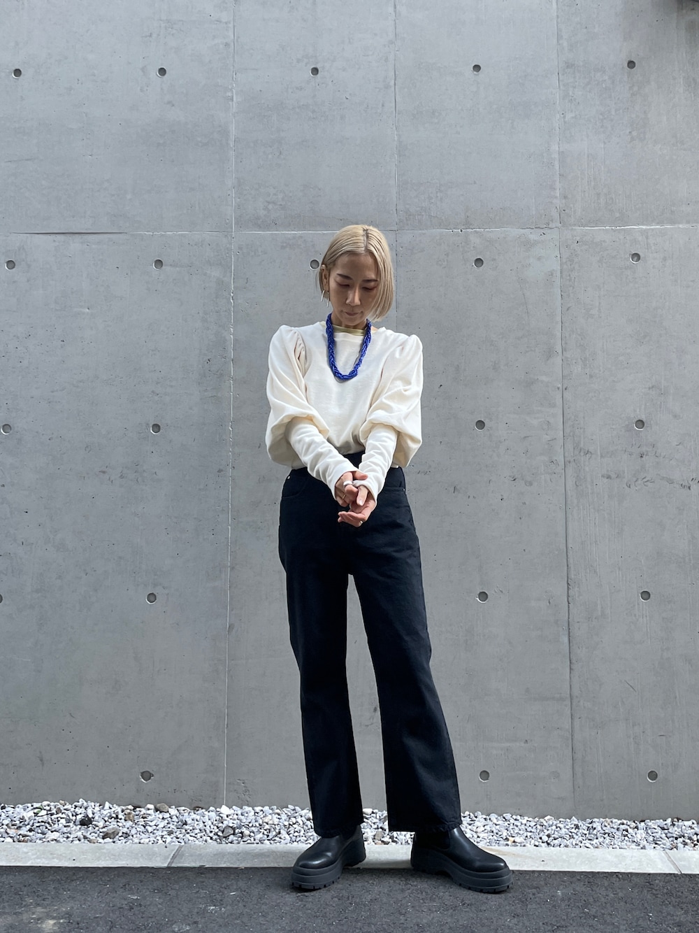 ホワイト系のTシャツ/カットソー、ブラック系のデニムパンツ、ブラック系のブーツを着用したレディースの冬コーディネートの1枚目の写真