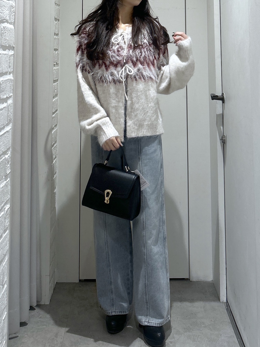 ホワイト系のニット/セーター、ブルー系のデニムパンツ、ブラック系のトートバッグを着用したレディースの秋コーディネートの1枚目の写真
