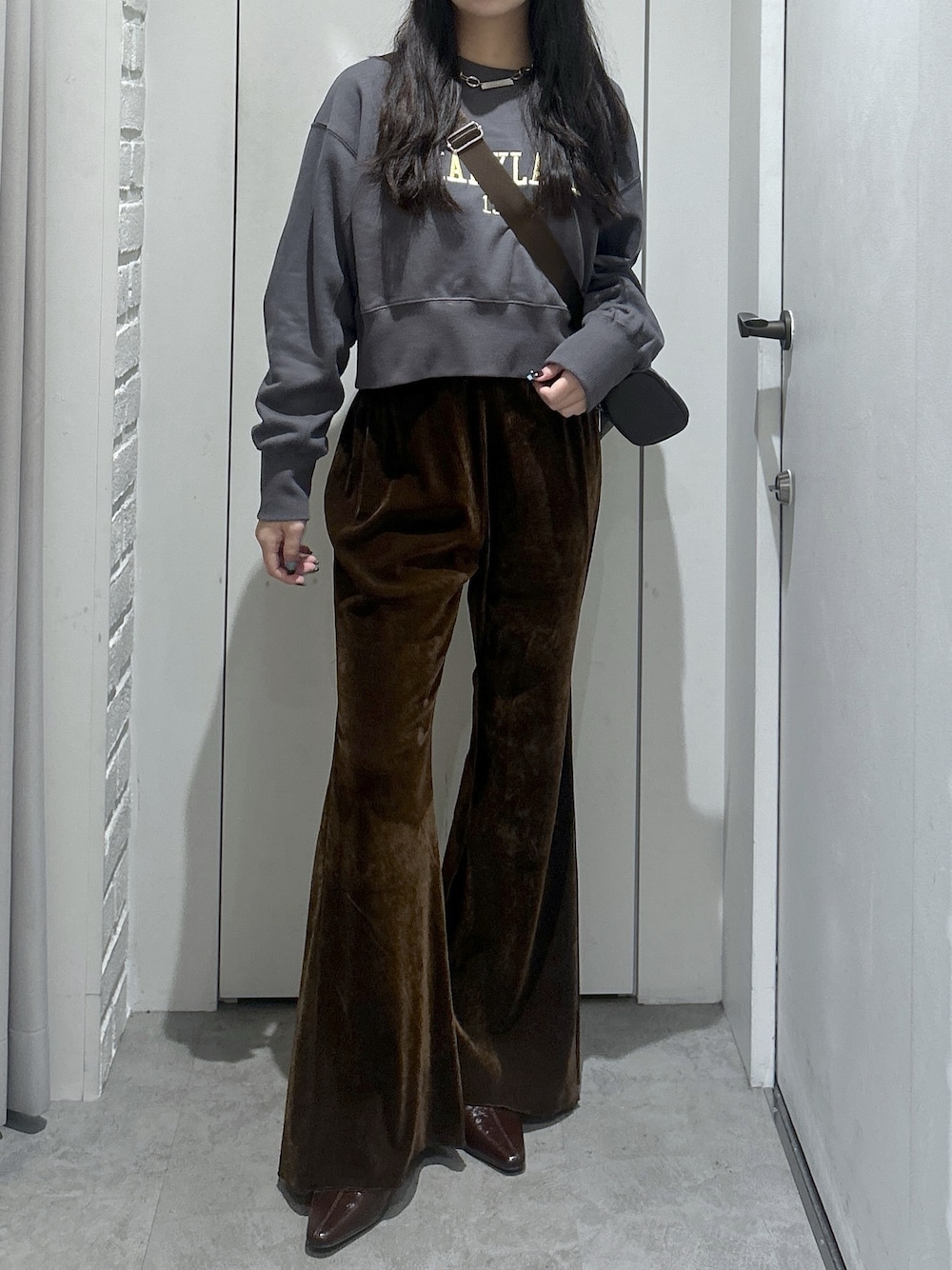 ブラック系のスウェット、ブラウン系のショルダーバッグ、ブラウン系のその他パンツを着用したレディースの秋コーディネートの1枚目の写真