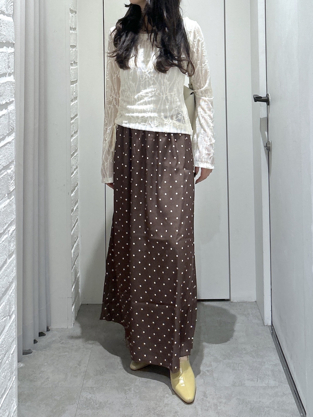 ホワイト系のショルダーバッグ、ホワイト系のTシャツ/カットソー、ベージュ系のパンプスを着用したレディースの秋コーディネートの1枚目の写真