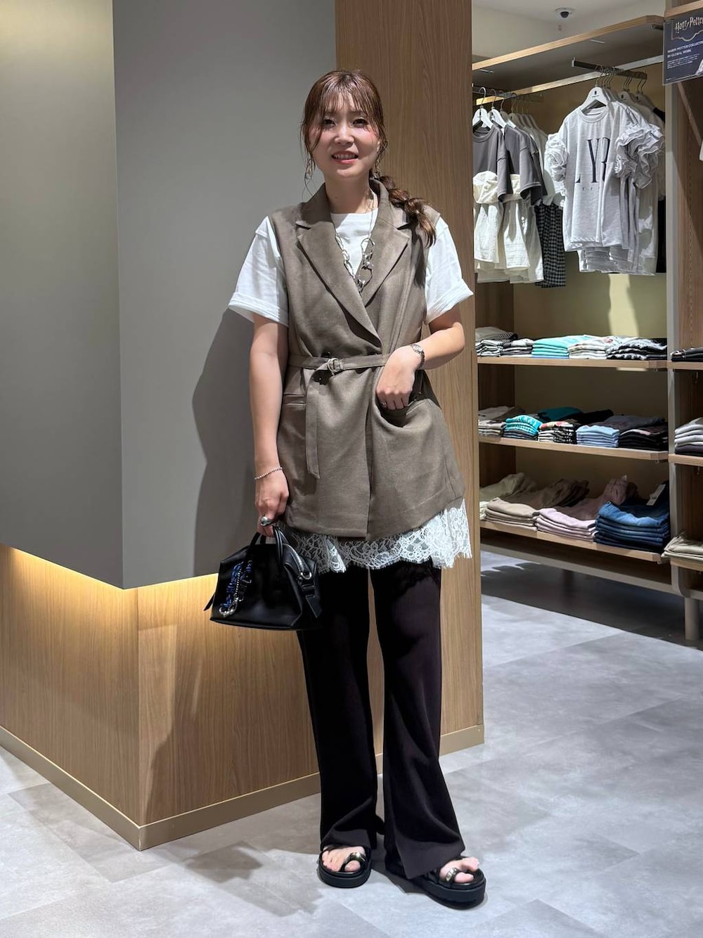 ブラウン系のベスト、ホワイト系のTシャツ/カットソー、ブラック系のボストンバッグを着用したレディースの夏コーディネートの1枚目の写真
