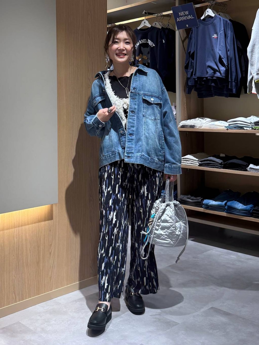 ブラック系のローファー、シルバー系のハンドバッグ、ブルー系のデニムジャケットを着用したレディースの春コーディネートの1枚目の写真