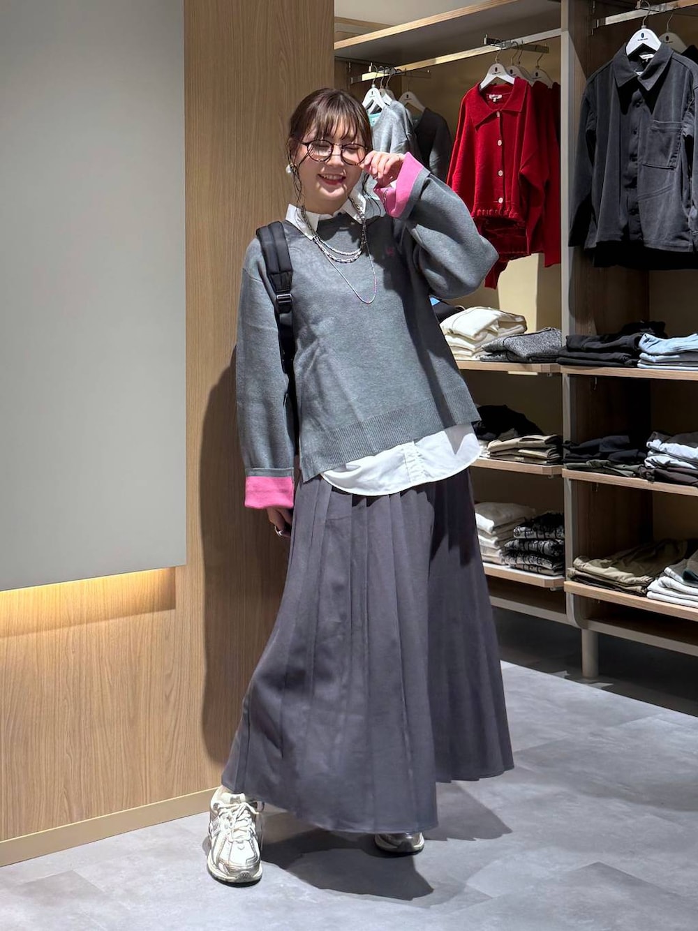 ホワイト系のシャツ/ブラウス、ブラック系のバックパック/リュック、グレー系のニット/セーターを着用したレディースの秋コーディネートの1枚目の写真