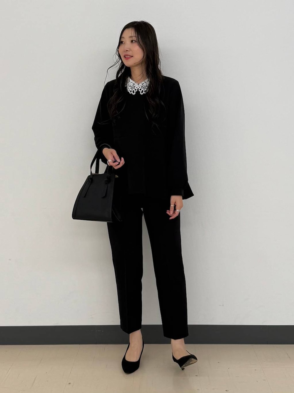 ブラック系のショルダーバッグ、ブラック系のセットアップ、ブラック系のパンプスを着用したレディースの冬コーディネートの1枚目の写真