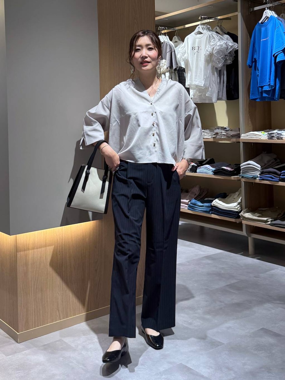 ブラック系のパンプス、ホワイト系のショルダーバッグ、ブルー系のその他パンツを着用したレディースの夏コーディネートの1枚目の写真